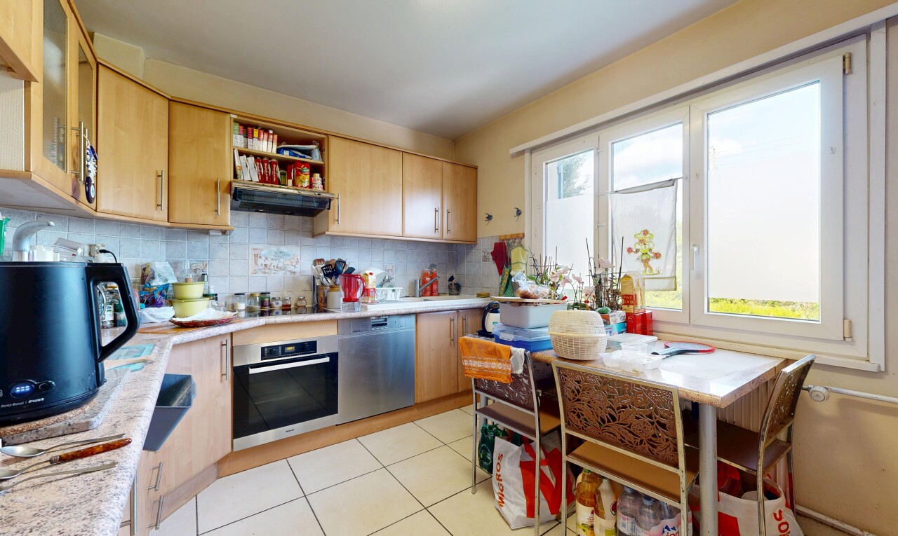 cuisine avec armoires marron clair, four, dosseret, backsplash, et inside property