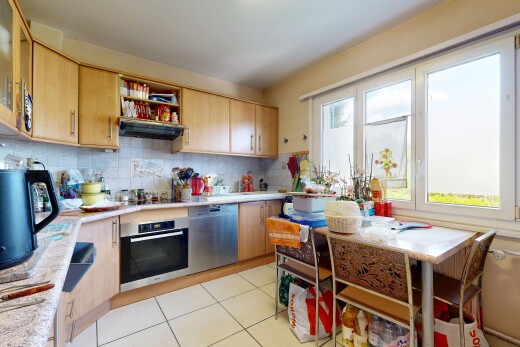 cuisine avec armoires marron clair, four, dosseret, backsplash, et inside property