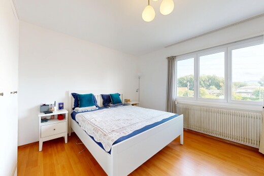 chambre avec radiateur, lumière naturelle, natural light, sol en finition bois, et wood finish floor