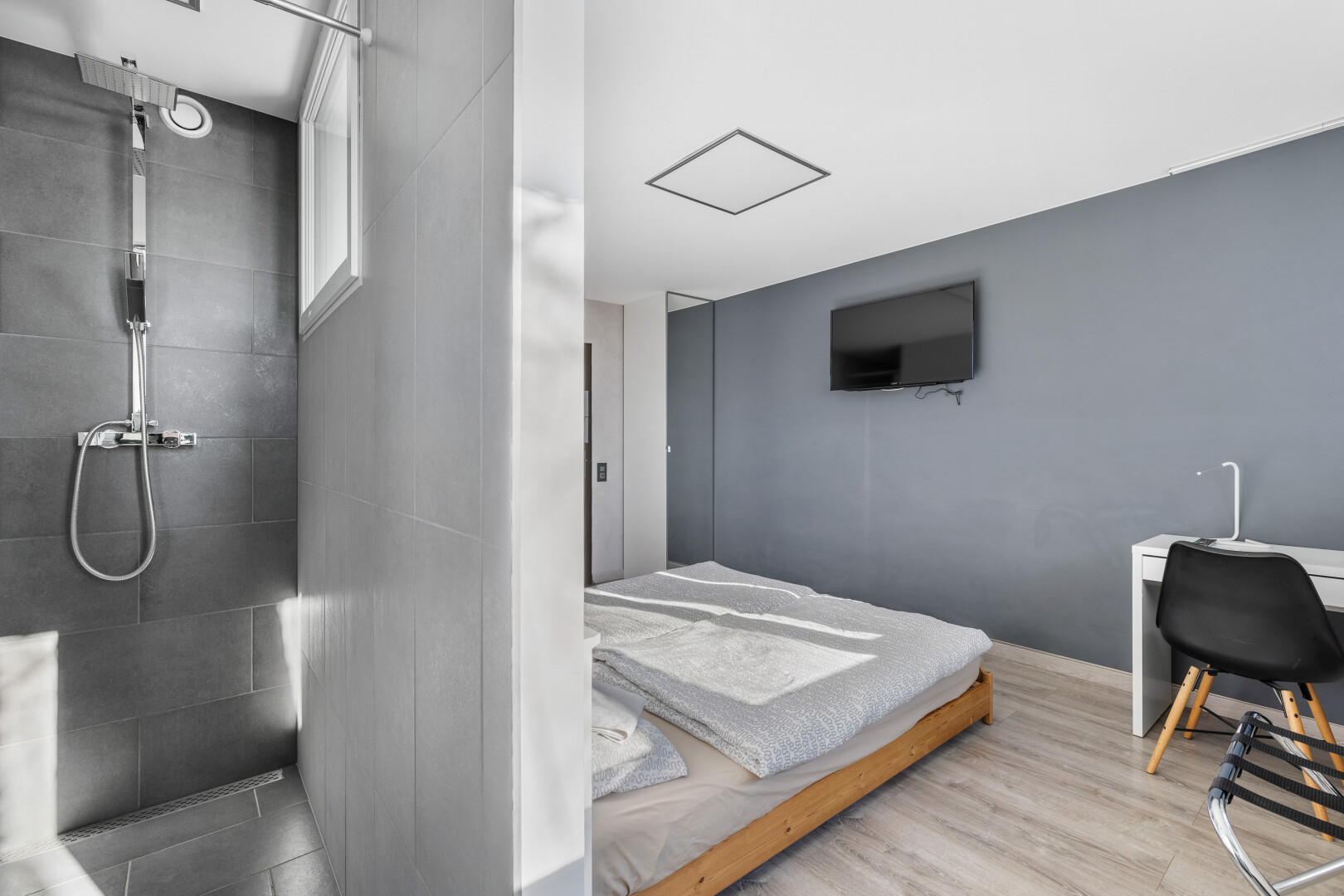 zimmer / schlafzimmer mit fernseher und holzfußboden