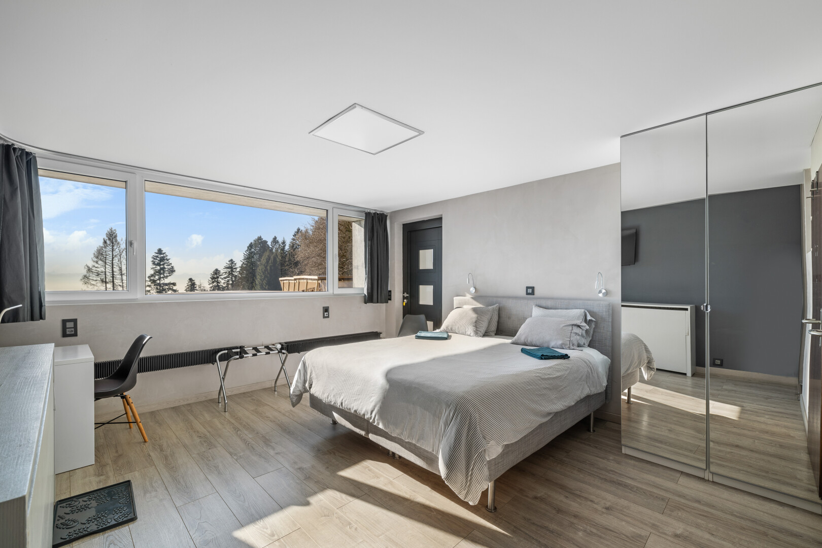 zimmer / schlafzimmer mit holzfußboden, natürliches licht, und gipskartonwand