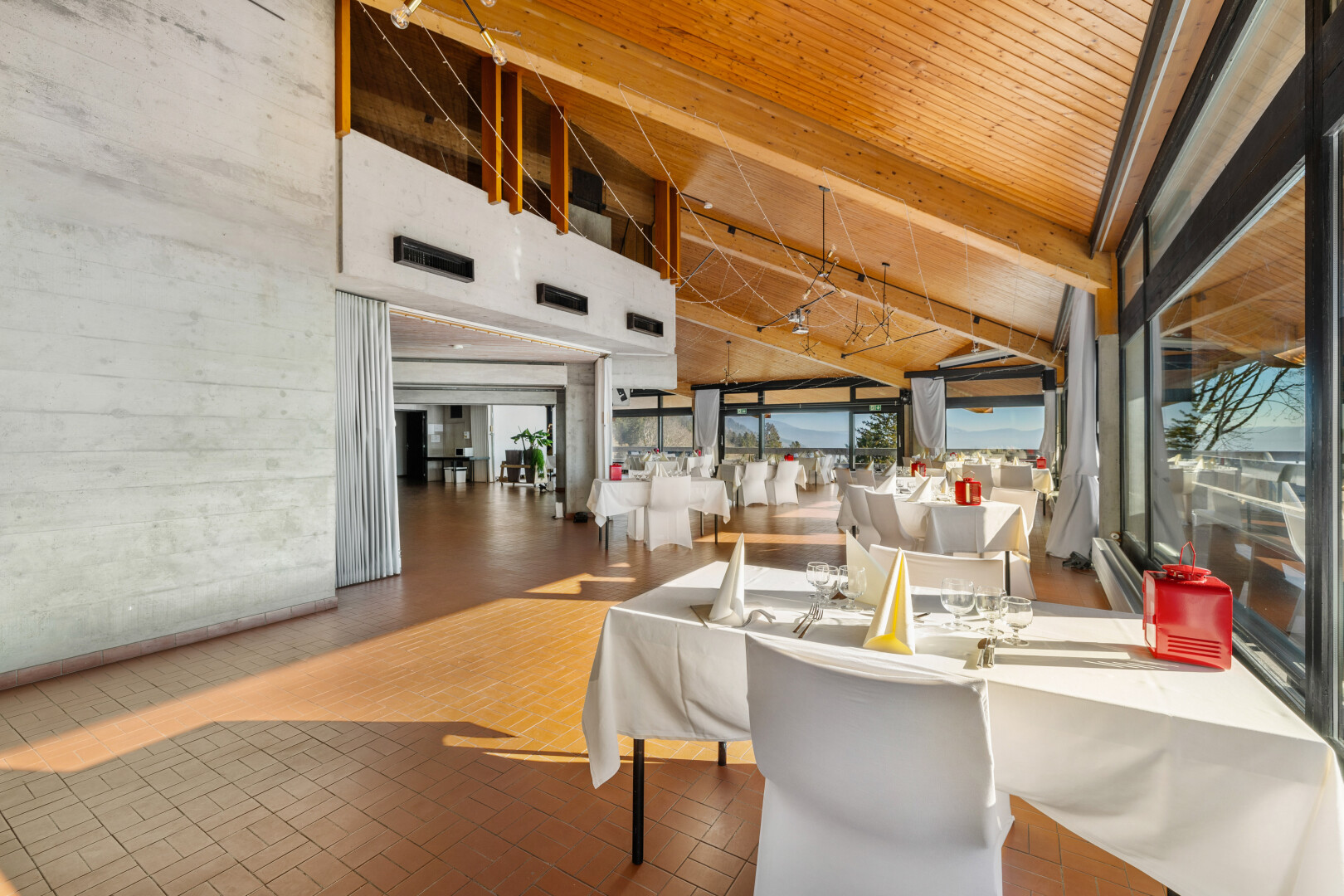 esszimmer mit lüftungsgitter, hohe decke, ziegelfußboden, und betonmauer