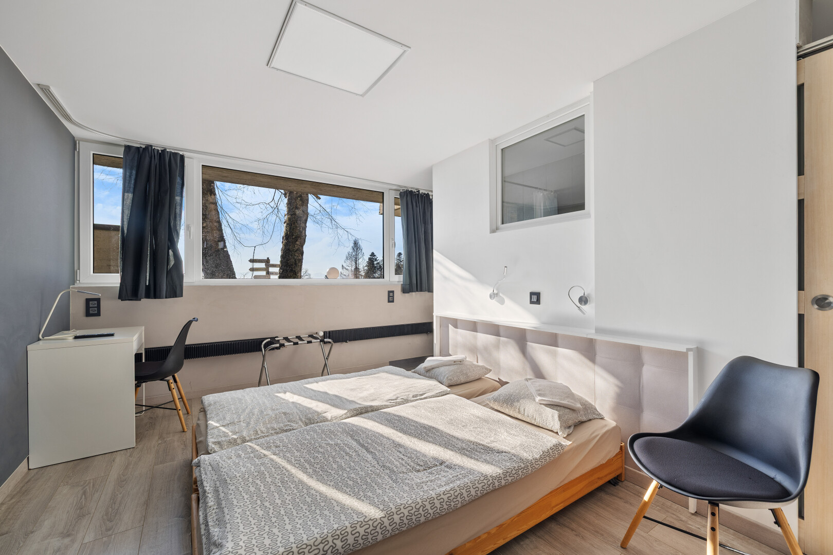 zimmer / schlafzimmer mit natürliches licht, gipskartonwand, und holzfußboden