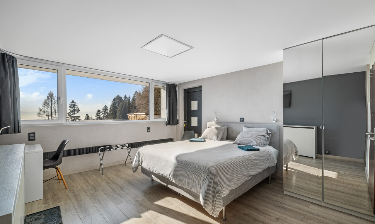 chambre avec sol en finition bois, lumière naturelle, et cloison sèche