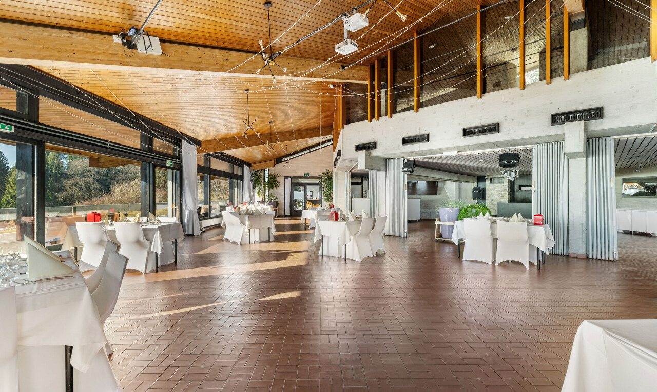 salle à manger avec plafond haut, lumière naturelle, et sol en finition brique