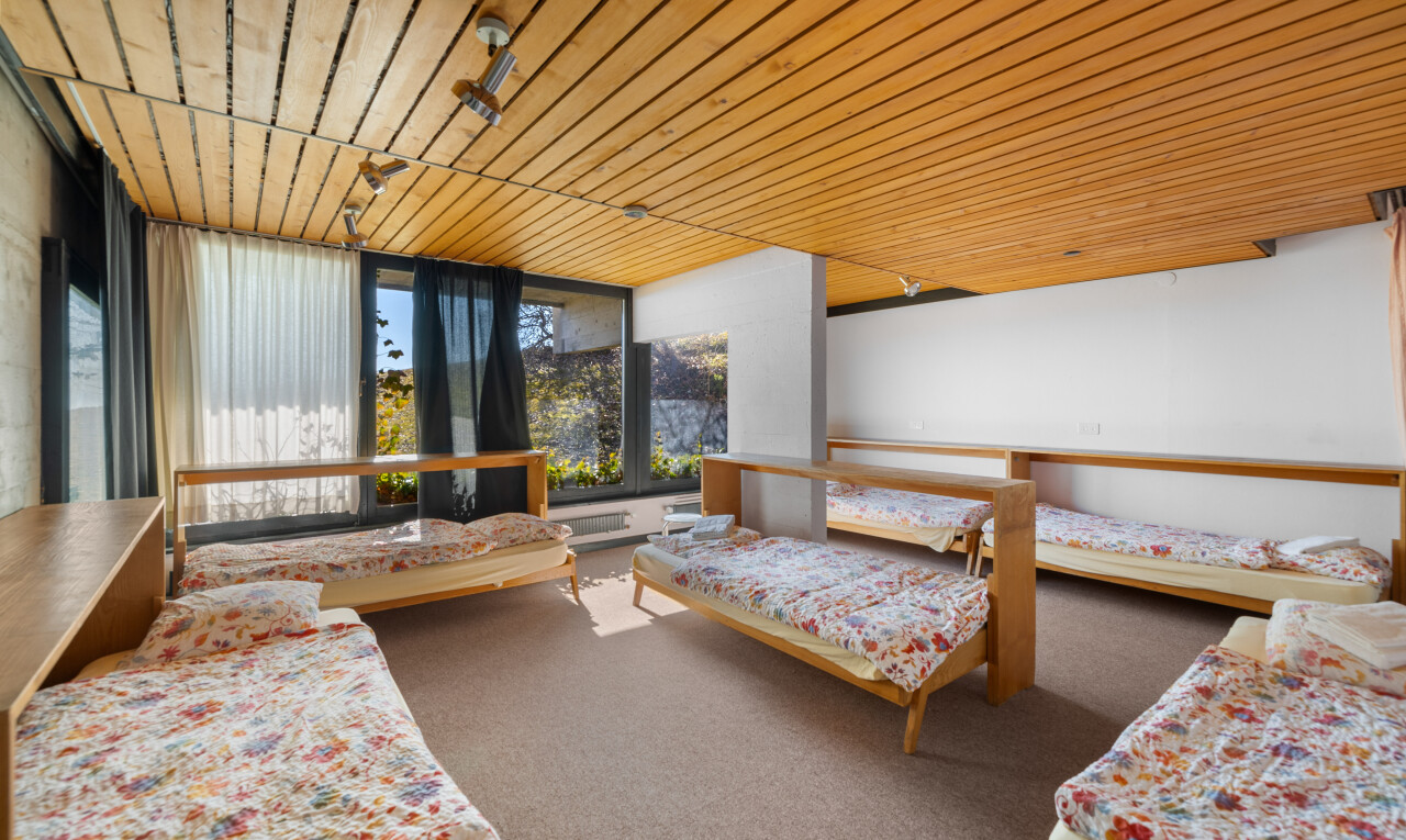 chambre avec plafond en bois, moquette, cloison sèche, et lumière naturelle
