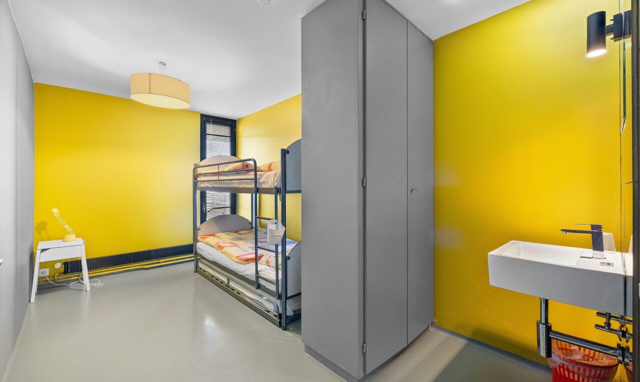 espace intérieur avec sol en béton, cloison sèche, détecteur de fumée et de monoxyde de carbone, et armoires à charnières visibles