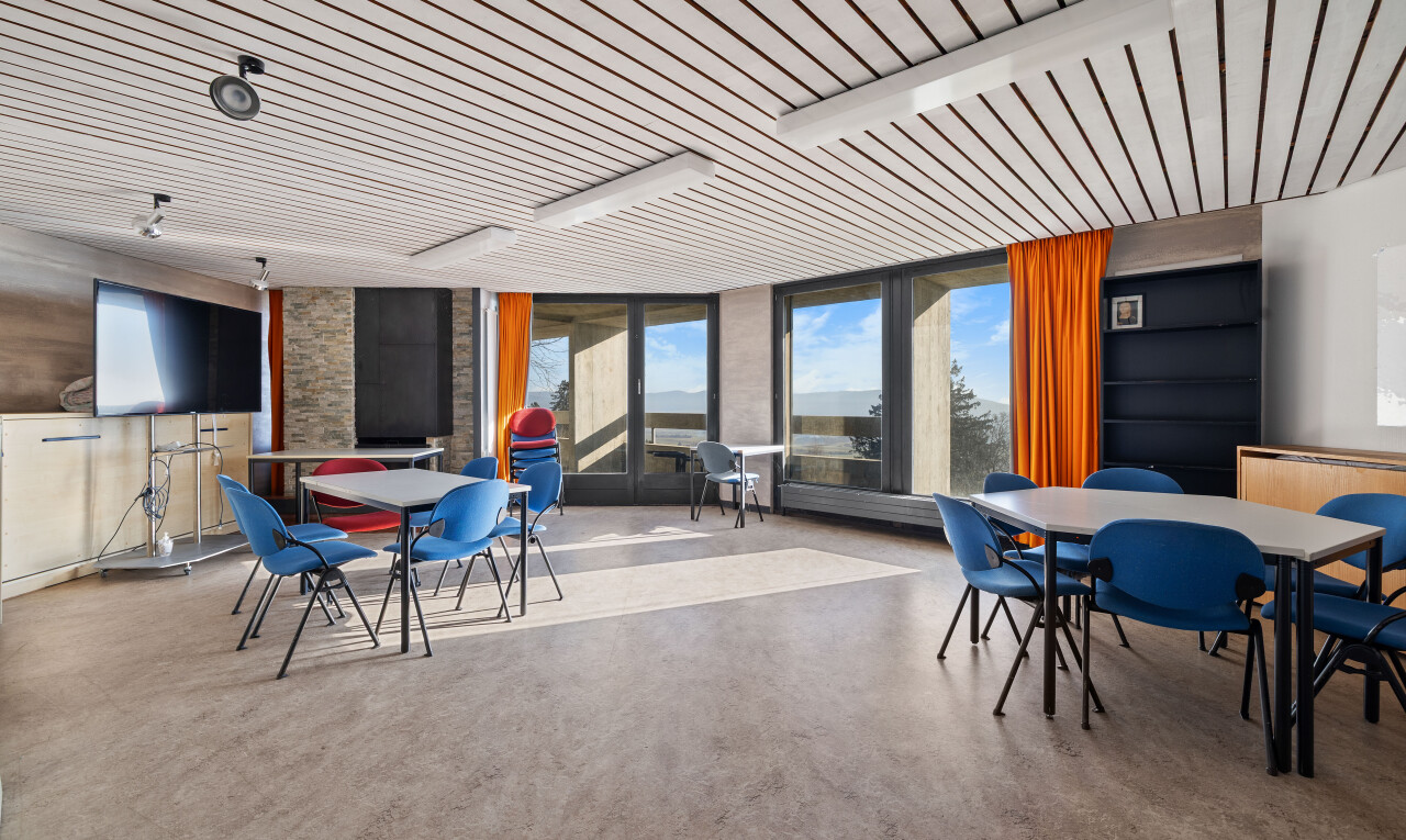 salon / salle à manger avec lumière naturelle, télévision, fenêtres du sol au plafond, cloison sèche, et sol en béton