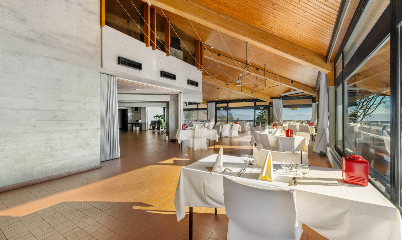 salle à manger avec plafond haut, ventilation, mur en béton, et sol en finition brique