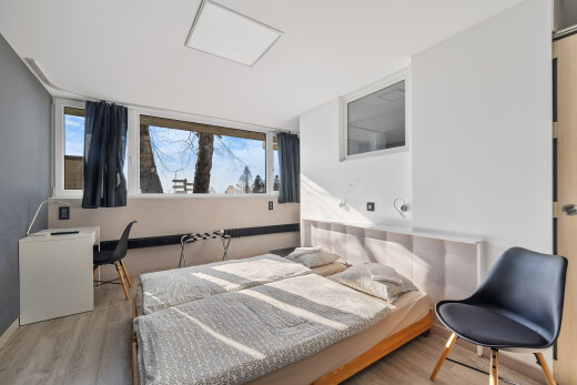 zimmer / schlafzimmer mit natürliches licht, gipskartonwand, und holzfußboden
