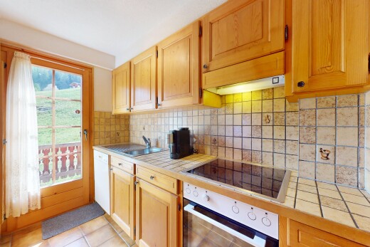 küche mit ofen, fliesenarbeitsplatten, herd, geschirrspülmaschine, und schränke mit sichtbaren scharnieren