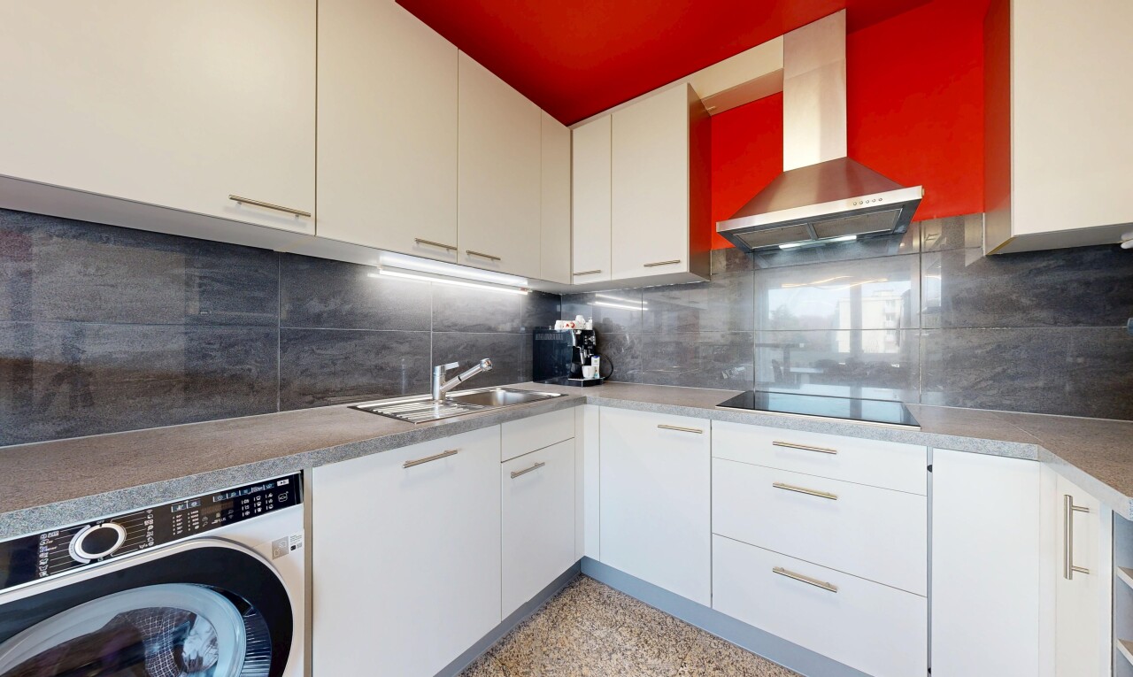 kitchen with washer / clothes dryer, decorative backsplash, white cabinetry, black electric cooktop, and light countertops
