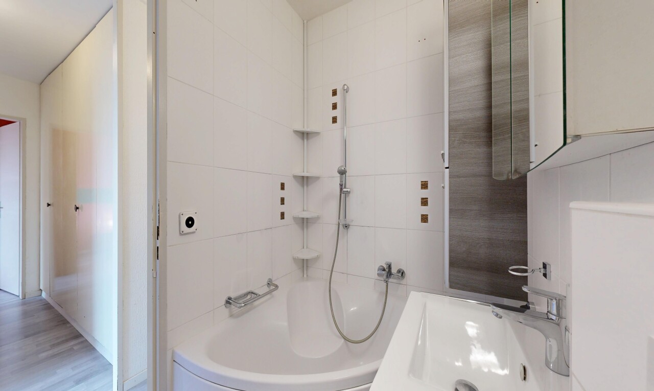 bathroom with tile walls, bathing tub / shower combination, and vanity