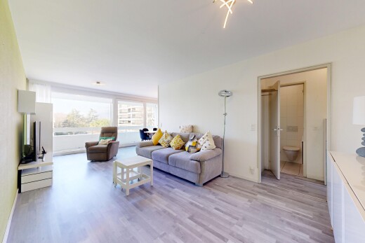 salon avec natural light, lumière naturelle, wood finish floor, sol en finition bois, et drywall