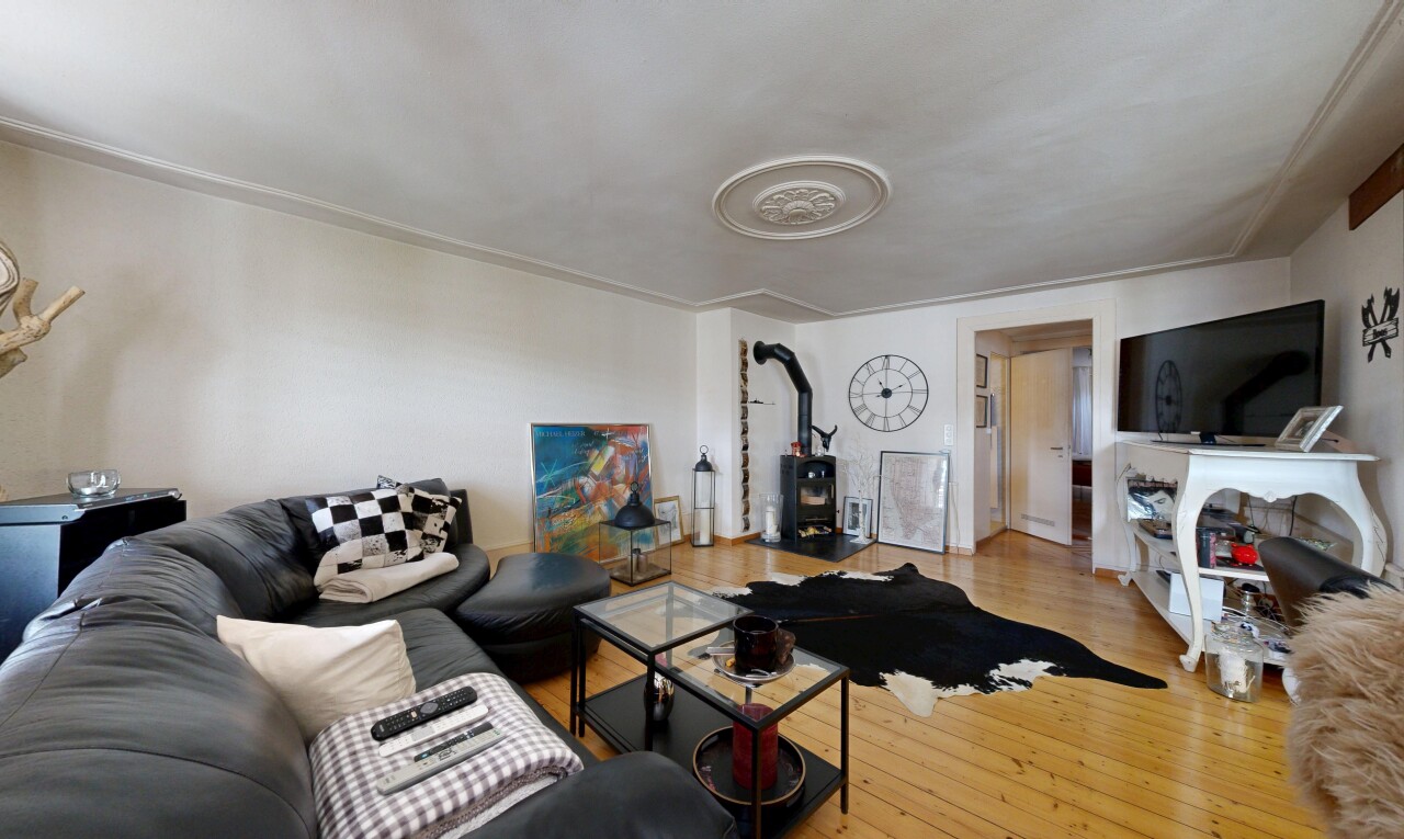wohnzimmer mit wood finish floor, holzfußboden, fernseher, inside property, und drywall