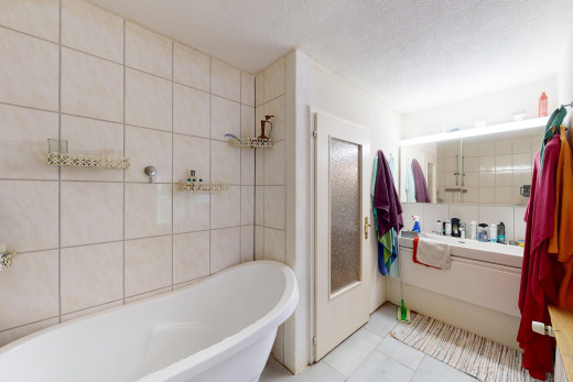 salle de bains avec carrelage, mur carrelé, baignoire, et plafond en crépis