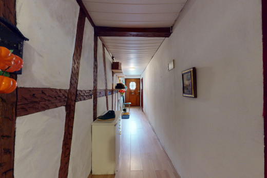 couloir avec poutres apparentes, lumière naturelle, et plancher de bois