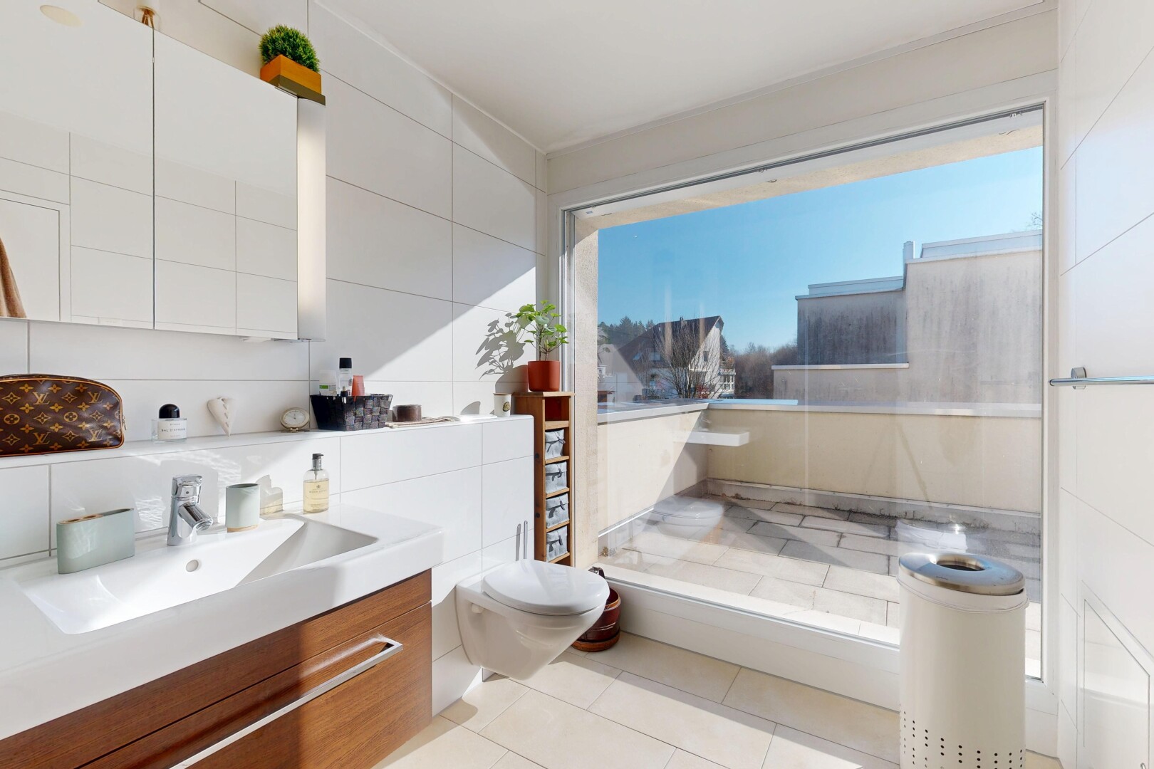 salle de bains avec miroir, mur en carrelage, tile wall, lavabo (ou coiffeuse selon le contexte), et évier