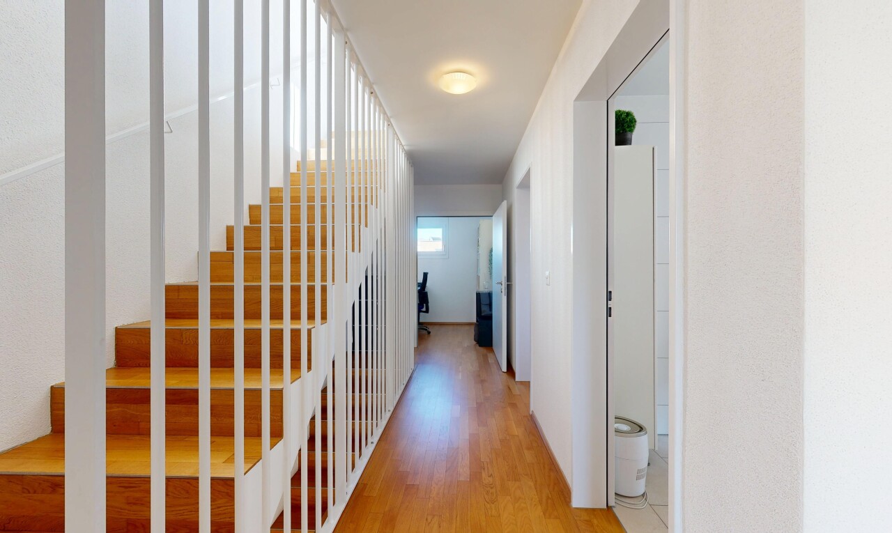 couloir avec wood finish floor, sol en finition bois, inside property, escaliers, et drywall