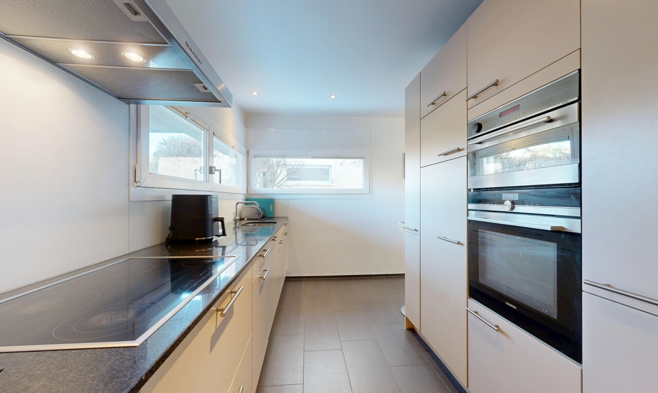 cuisine avec hotte, four double, plaque de cuisson, inside property, et white cabinets