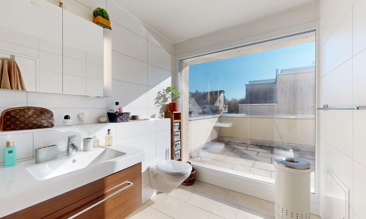 salle de bains avec miroir, mur en carrelage, tile wall, lavabo (ou coiffeuse selon le contexte), et évier