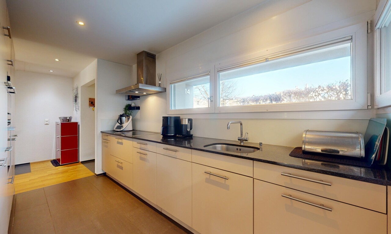 cuisine avec hotte, dark countertops, évier, inside property, et éclairage encastré