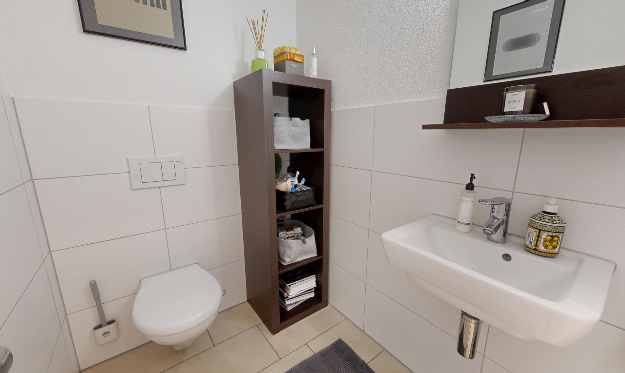 salle de bains avec mur en carrelage, tile wall, inside property, évier, et toilette