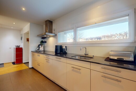cuisine avec hotte, dark countertops, évier, inside property, et éclairage encastré