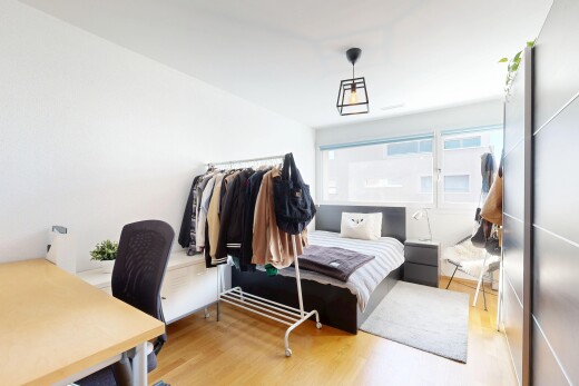 chambre avec espace bureau, wood finish floor, sol en finition bois, inside property, et natural light