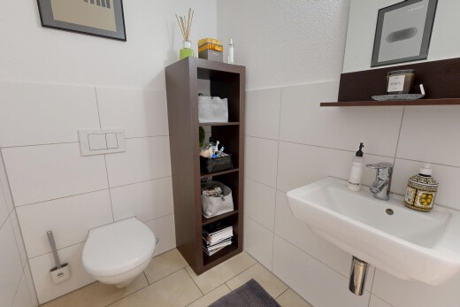 salle de bains avec mur en carrelage, tile wall, inside property, évier, et toilette