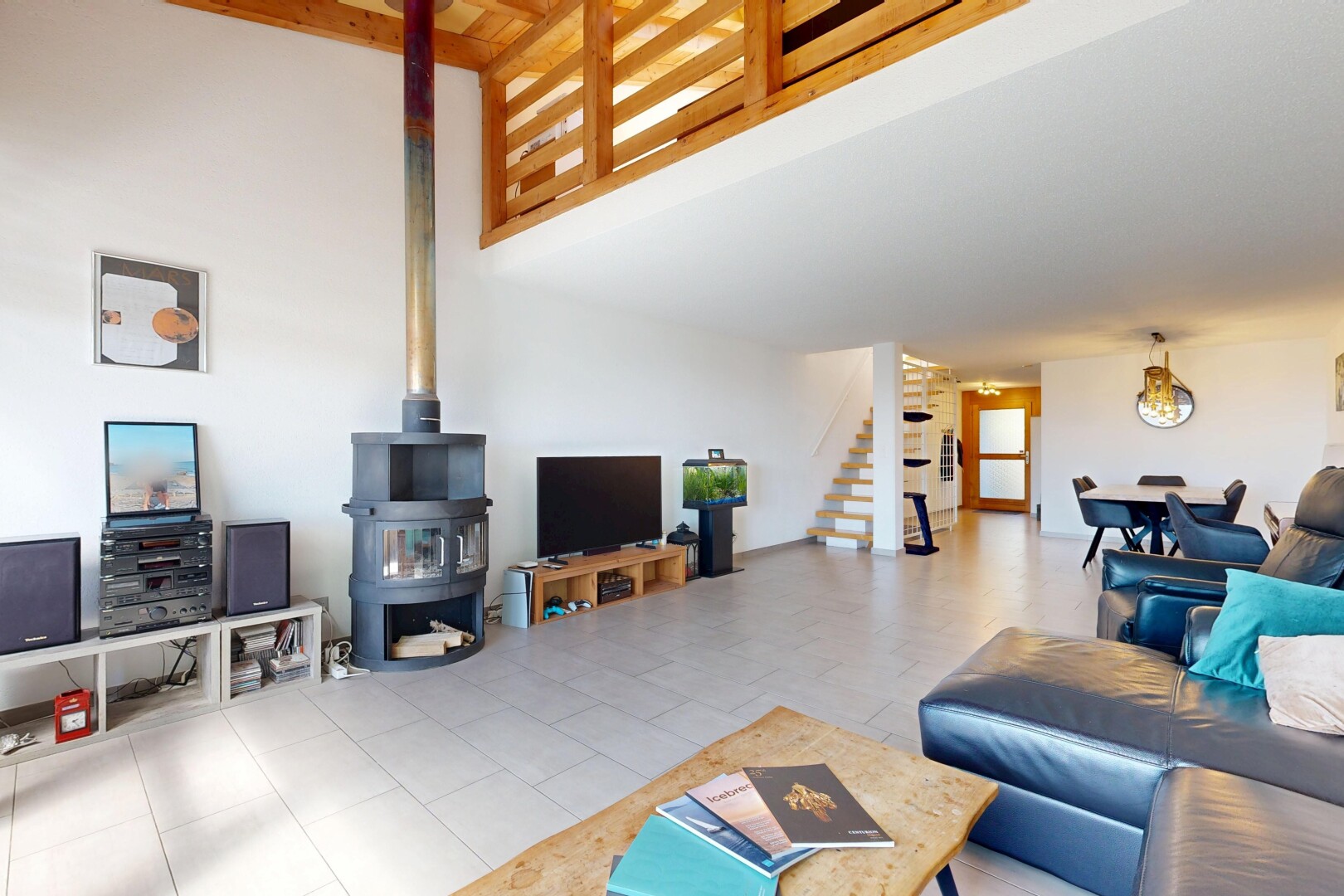 wohnzimmer mit holzofen, treppen, gipskartonwand, drywall, und fernseher
