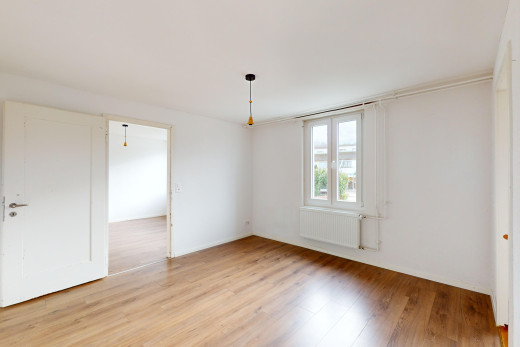 pièce vide avec radiateur, lumière naturelle, et plancher de bois