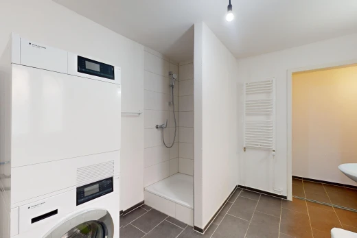 bathroom featuring tiled shower, radiator, and tile patterned flooring