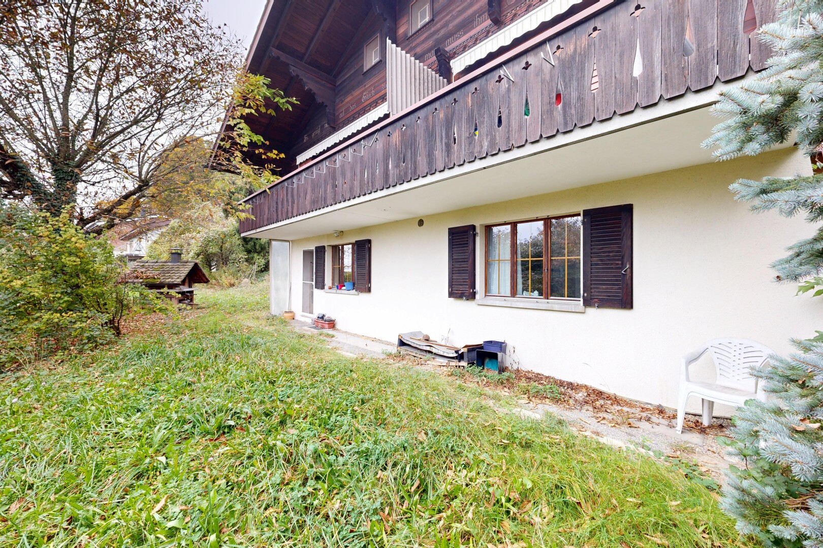 façade avec balcon, bardage en stuc, property visible, pelouse, et overcast