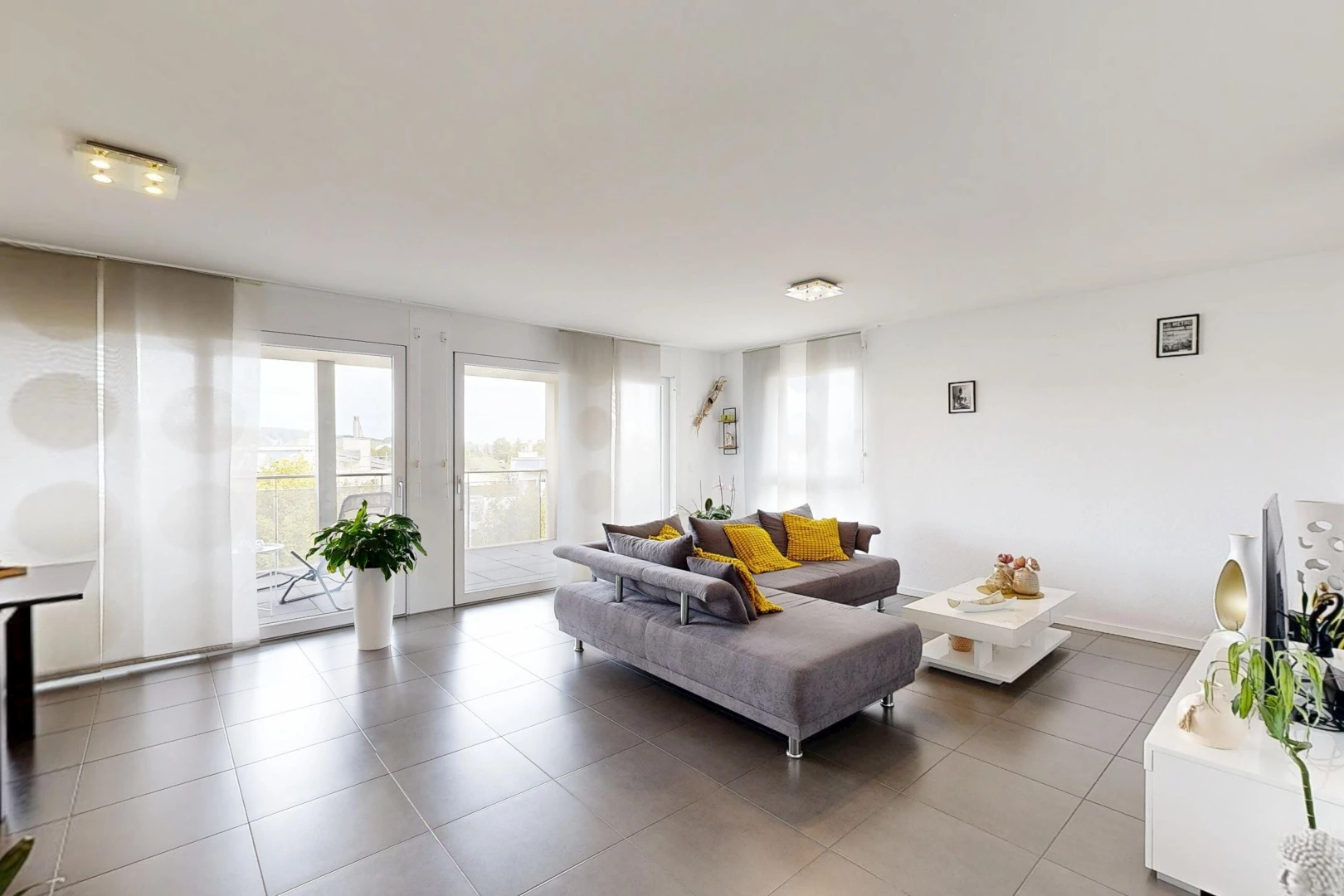 salon avec cloison sèche, drywall, inside property, accès à l'extérieur, et sol en carrelage