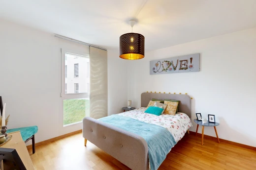 chambre avec lumière naturelle, drywall, cloison sèche, éclairage suspendu, et wood finish floor