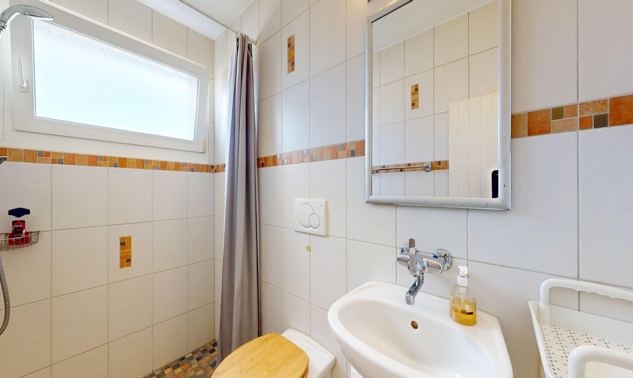 full bath with a shower stall and tile walls