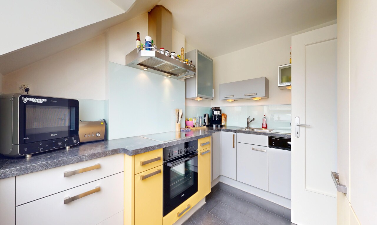 kitchen featuring black appliances, dark countertops, and glass fronted cabinets