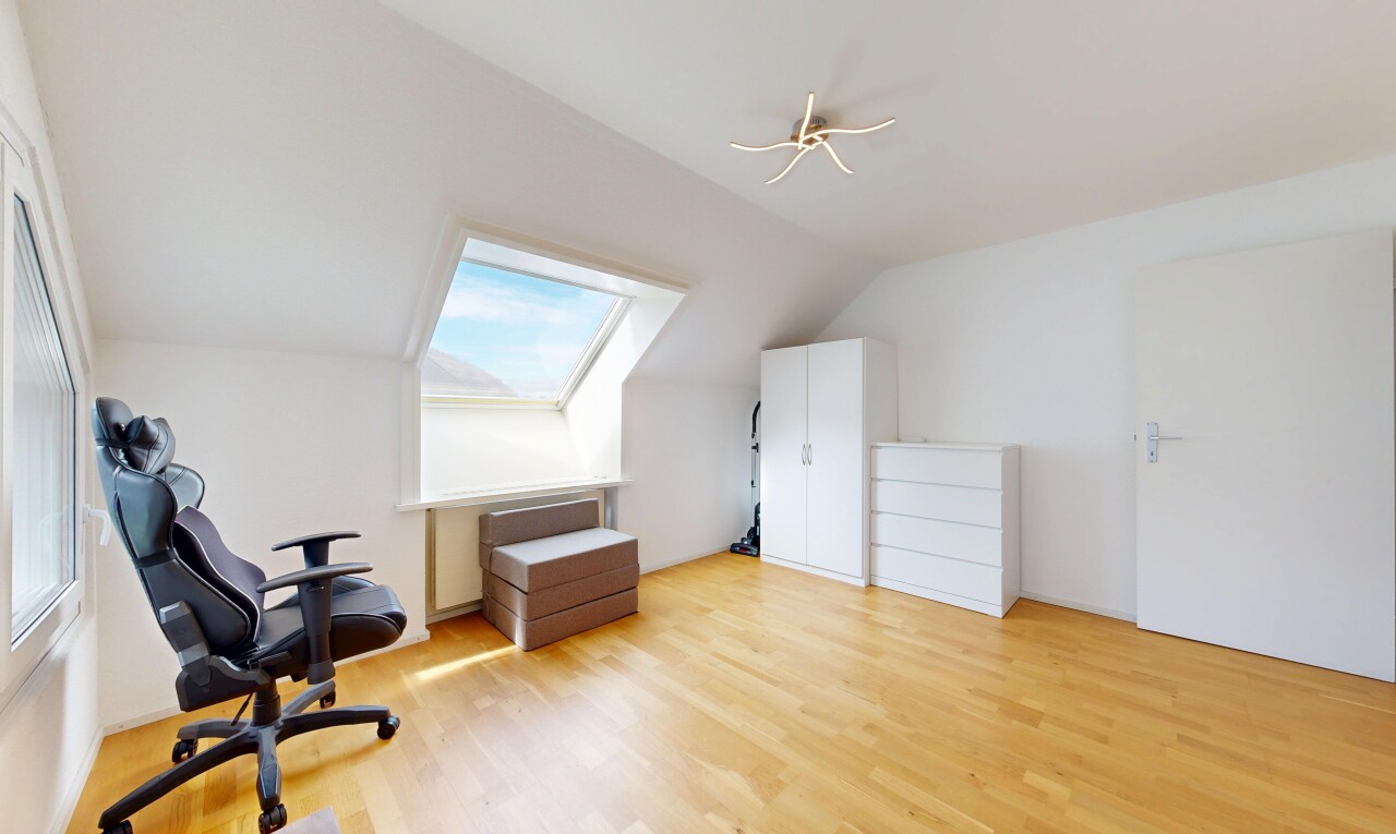 office area with light wood-type flooring, vaulted ceiling, and a skylight