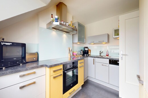 kitchen featuring black appliances, dark countertops, and glass fronted cabinets