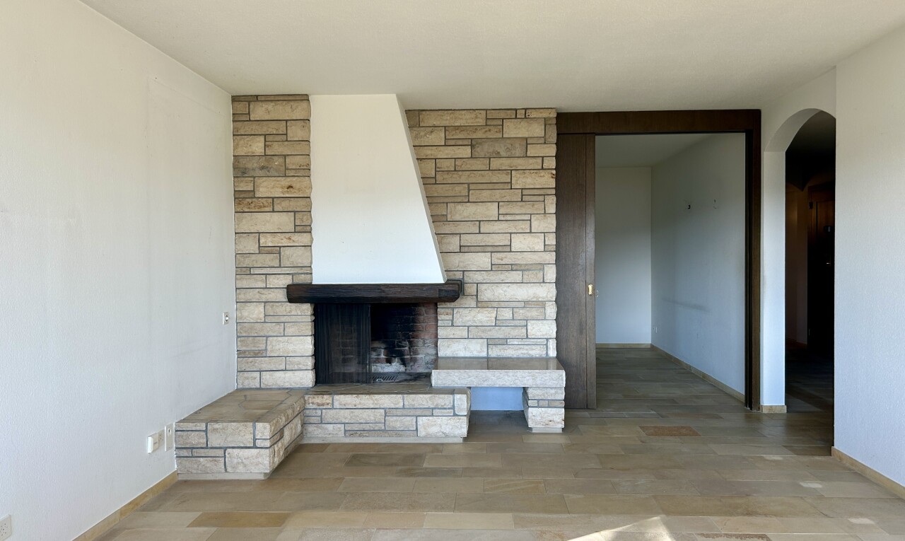 pièce vide avec passages en arc, cloison sèche, drywall, cheminée, et baseboards wall