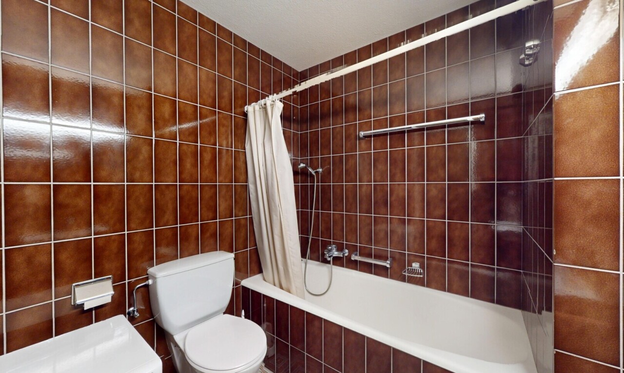 salle de bains avec tile tub, inside property, toilette, mur en carrelage, et tile wall