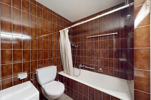 salle de bains avec tile tub, inside property, toilette, mur en carrelage, et tile wall