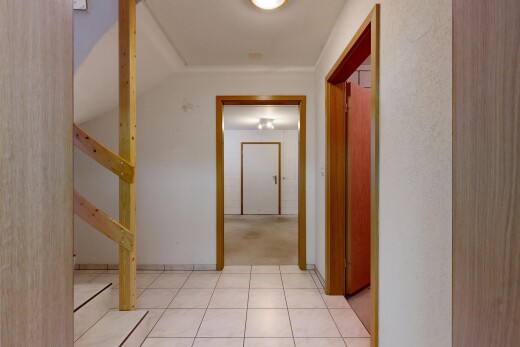 hallway with light tile patterned floors and stairs