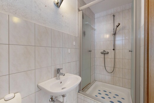 full bathroom with a stall shower and tile walls