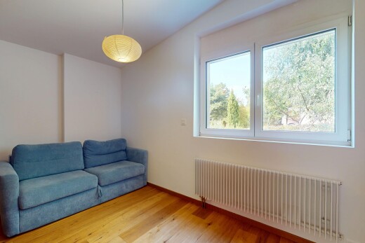 salon avec radiateur, sol en finition bois, wood finish floor, cloison sèche, et drywall