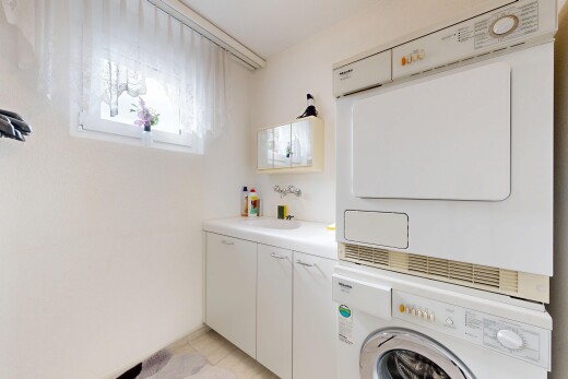 laundry area with stacked washer / drying machine and cabinet space