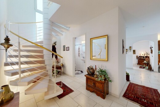escaliers avec passages en arc, cloison sèche, drywall, sol en carrelage, et tile floor