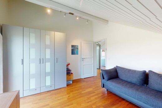 wohnzimmer mit vaulted ceiling, dachschräge, drywall, gipskartonwand, und wood finish floor