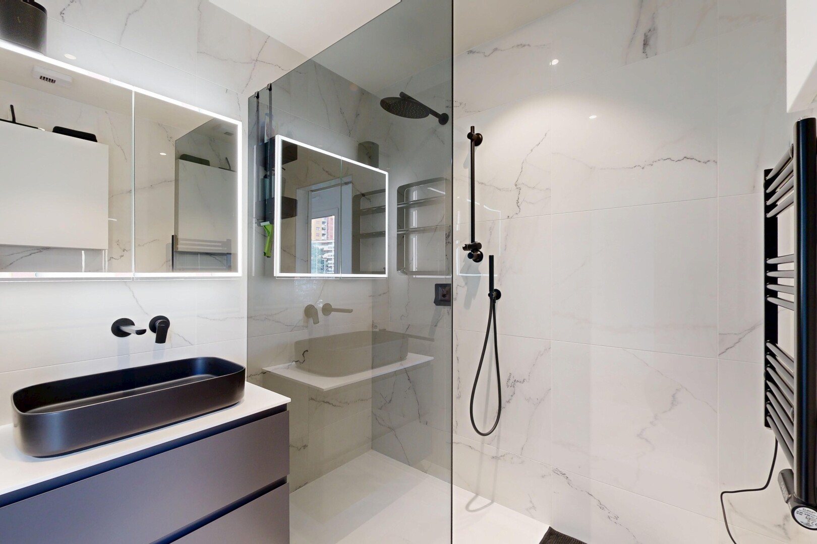 bathroom with a towel warmer, vanity, a marble finish shower, and radiator